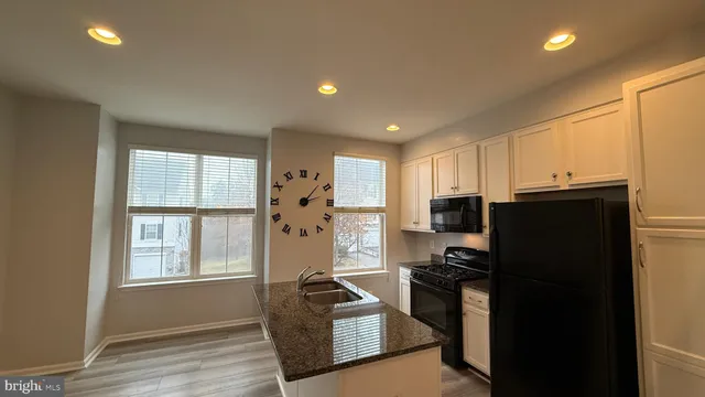 a kitchen with a refrigerator a stove top oven and a window