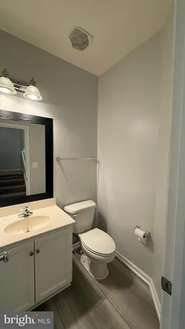 a bathroom with a toilet a sink and mirror
