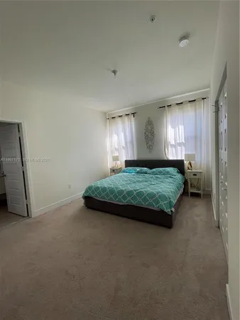 a spacious bedroom with a bed and a cabinets