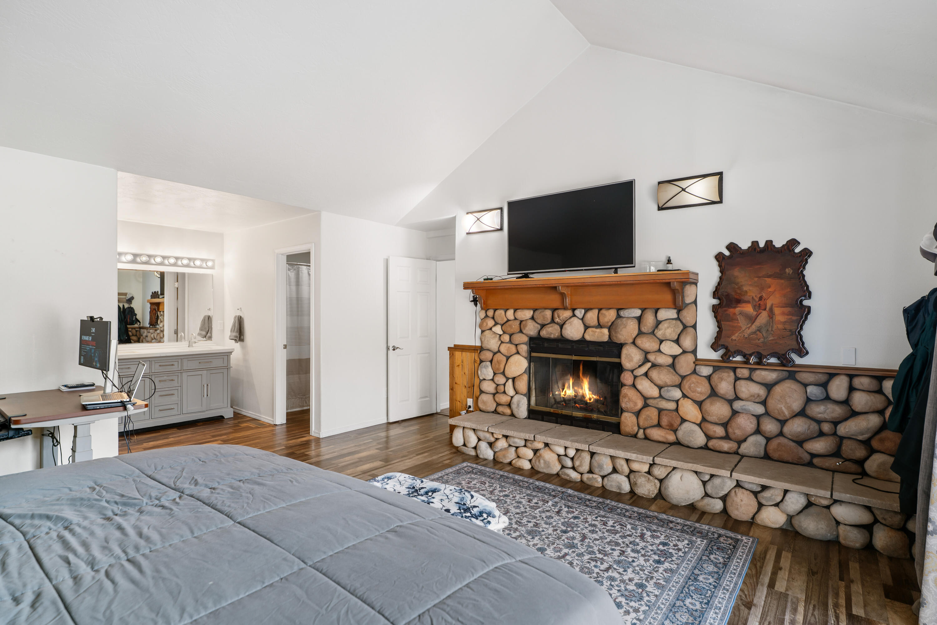 17062 Milky Way Bend, OR 97707 - Photo 17 of 39 Primary suite with private river-rock fireplace and en-suite vanity