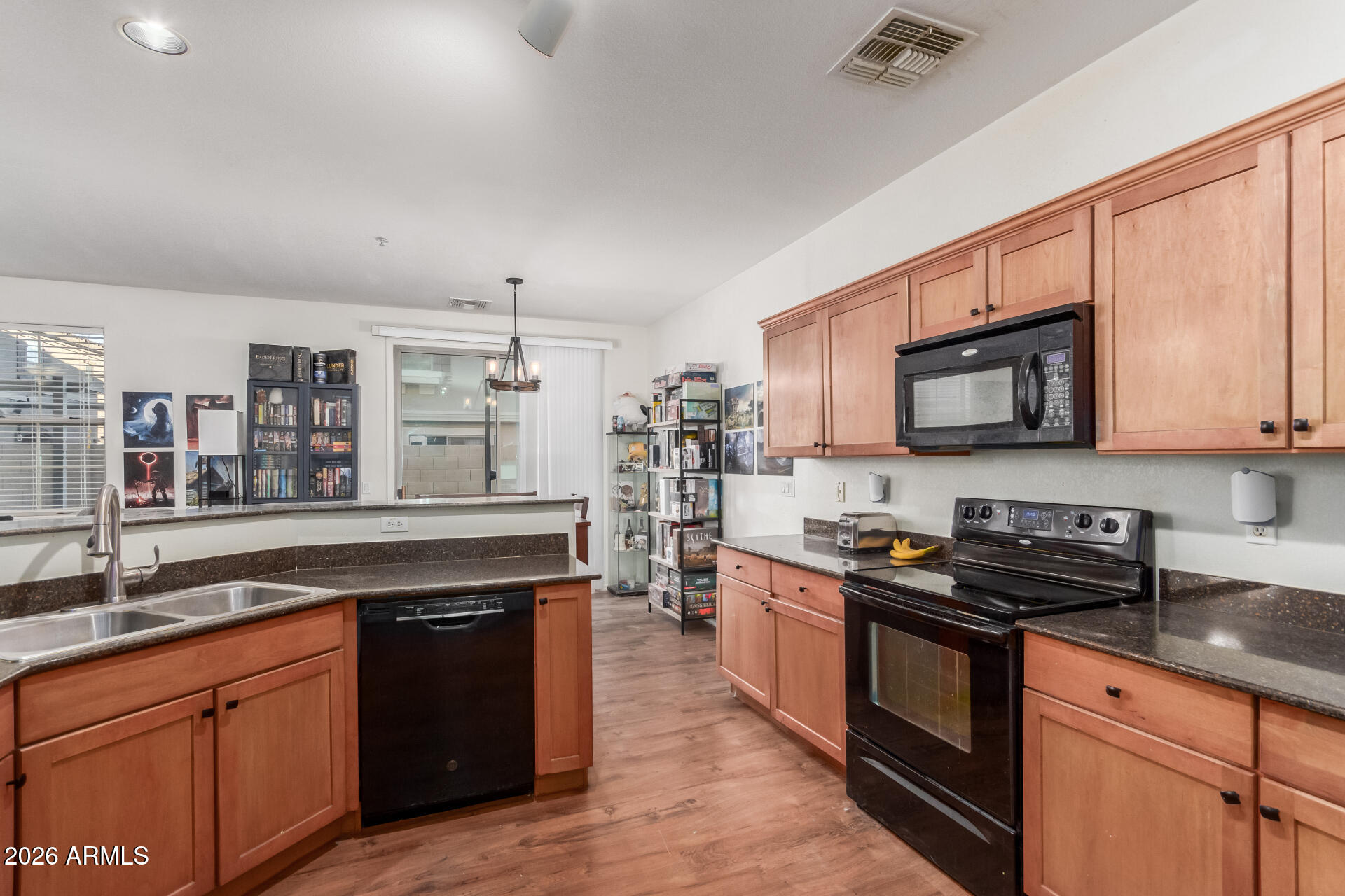 1265 South Aaron, Unit 346 Mesa, AZ 85209 - Photo 11 of 34 a kitchen with stainless steel appliances granite countertop a stove a sink dishwasher and a microwave oven with wooden cabinets