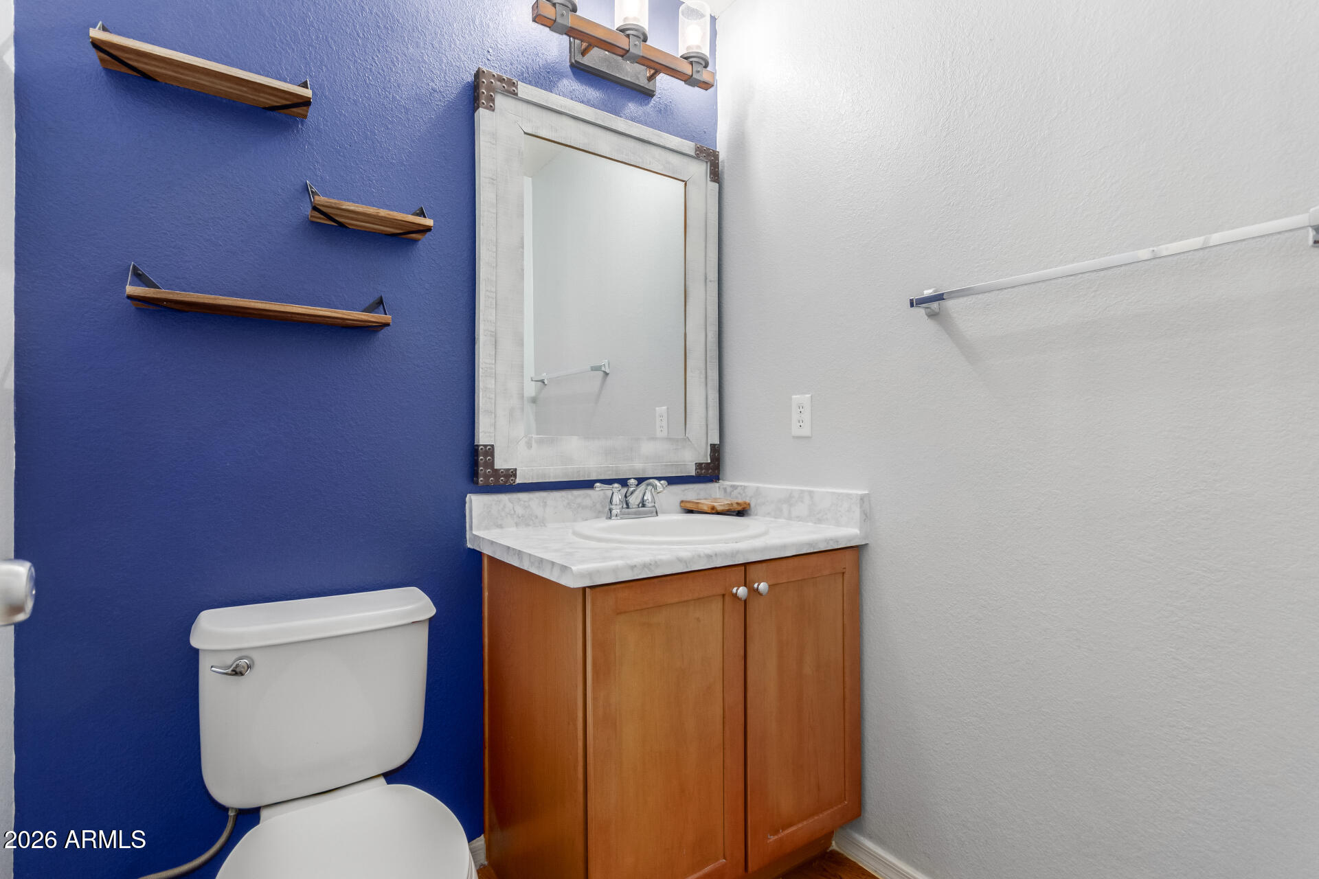 1265 South Aaron, Unit 346 Mesa, AZ 85209 - Photo 12 of 34 a bathroom with a toilet a sink and mirror