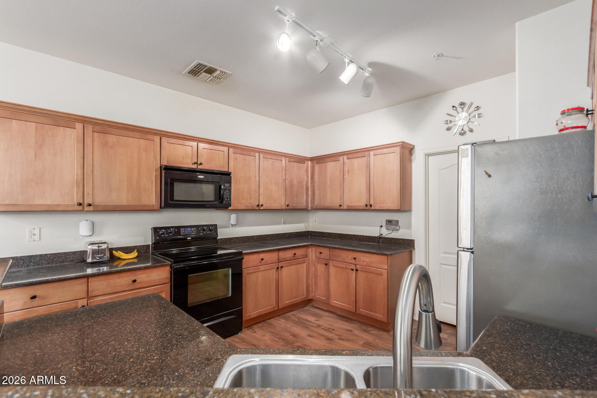 1265 South Aaron, Unit 346 Mesa, AZ 85209 - Photo 8 of 34 a kitchen with stainless steel appliances granite countertop a stove top oven a sink a dining table and chairs with wooden floor