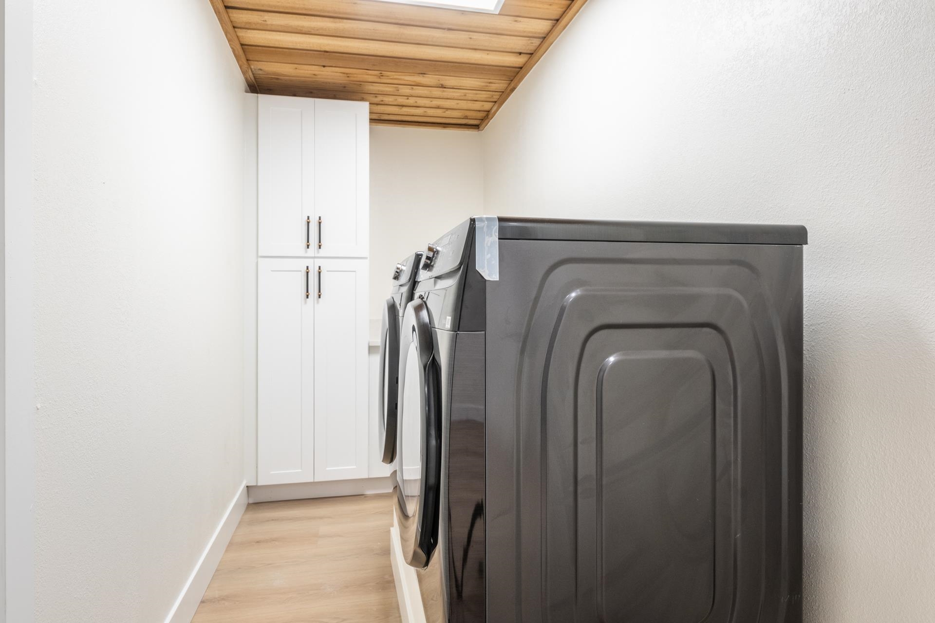 235 Forest Trail Mammoth Lakes, CA 93546 - Photo 29 of 35 Washroom with wood ceiling, washing machine and dryer, light wood-style floors, and cabinet space