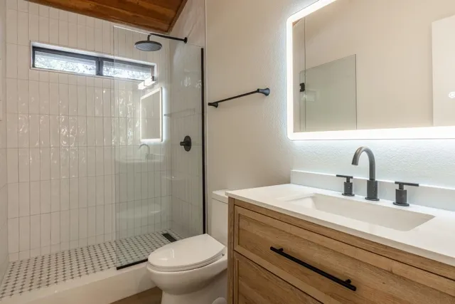 a bathroom with a sink a toilet and shower