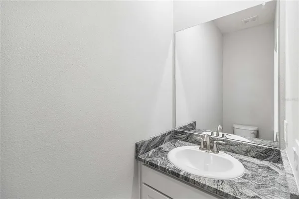 a bathroom with a granite countertop sink and a mirror