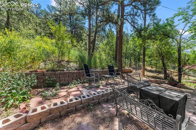 a view of backyard with a table and chairs under an umbrella