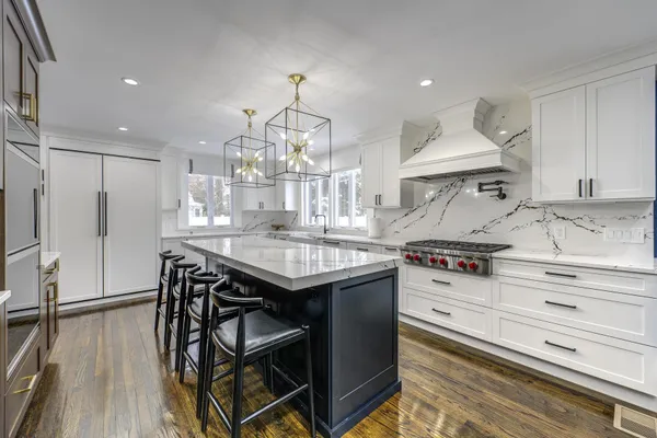 a kitchen with granite countertop a table chairs stove and refrigerator