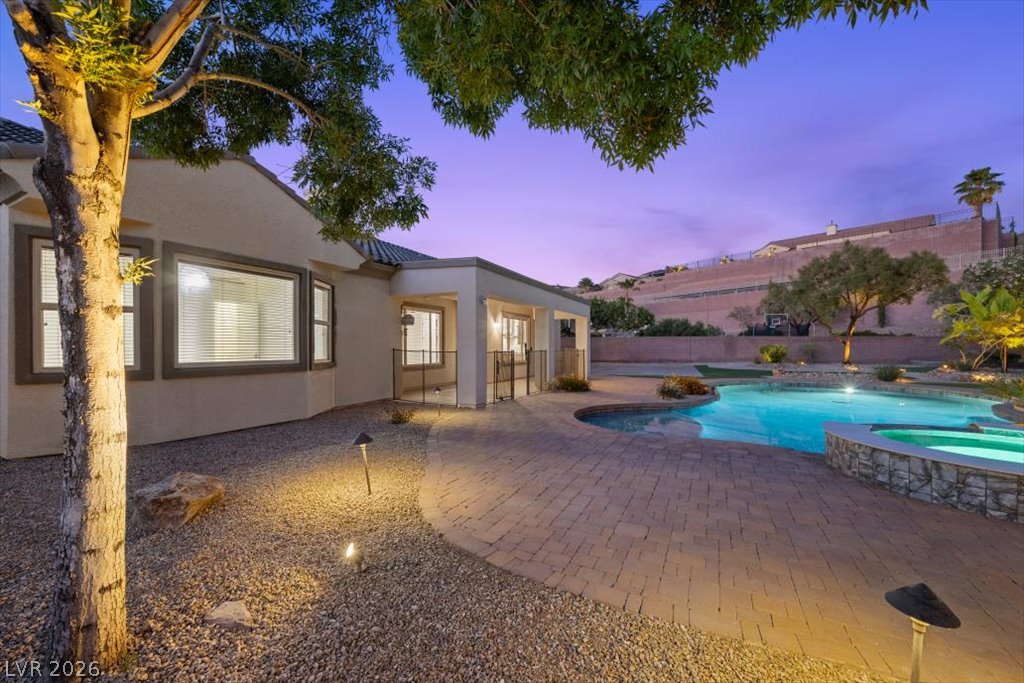 2125 De Rouge Avenue Henderson, NV 89044 - Photo 19 of 96 A private backyard oasis features a shimmering pool and spa, perfect for evening relaxation.