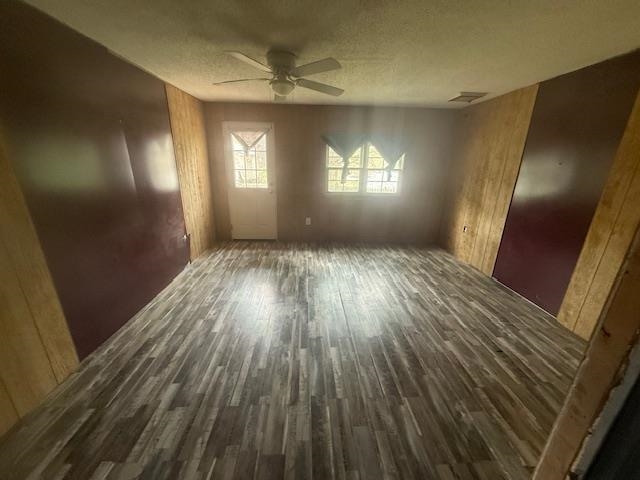 2310 Feddie Davis Road Ramer, TN 38367 - Photo 14 of 38 Unfurnished bedroom with dark wood finished floors, ceiling fan, a textured ceiling, and wood walls