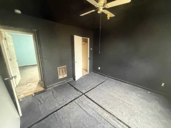 a view of an empty room with a chandelier fan