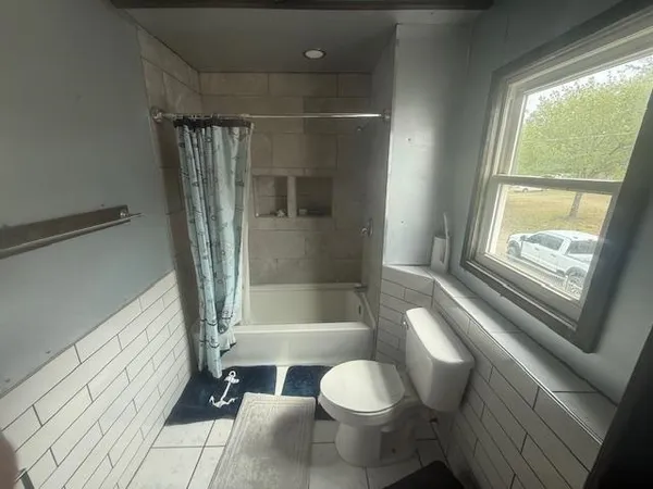 a bathroom with a bathtub a toilet a sink and a shower