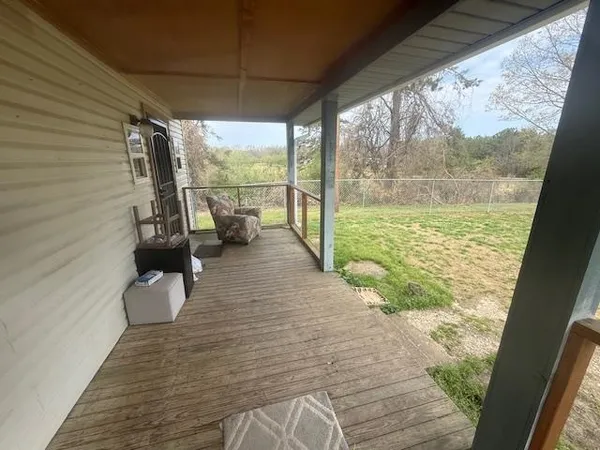a view of a balcony with chairs and wooden floor