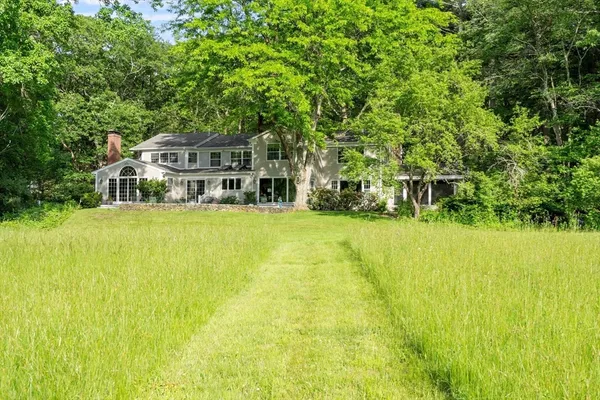 a house view with swimming pool in front of it