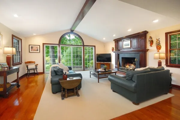 a living room with furniture a fireplace and a large window