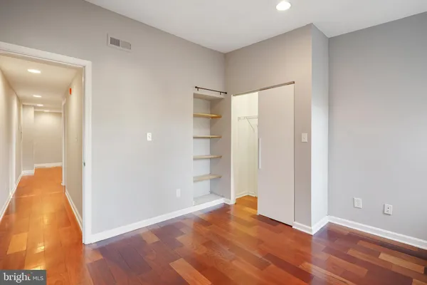 a view of an empty room with wooden floor