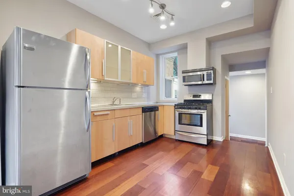 a kitchen with a refrigerator and a stove top oven