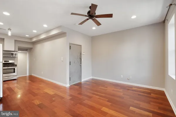 a view of empty room with wooden floor