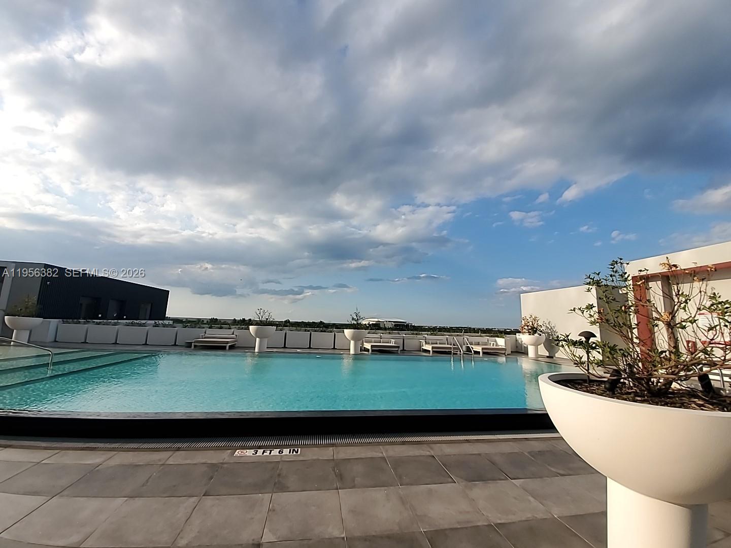 2000 Metropica Way, Unit 412 Sunrise, FL 33323 - Photo 13 of 18 a view of a swimming pool with an outdoor seating and a yard