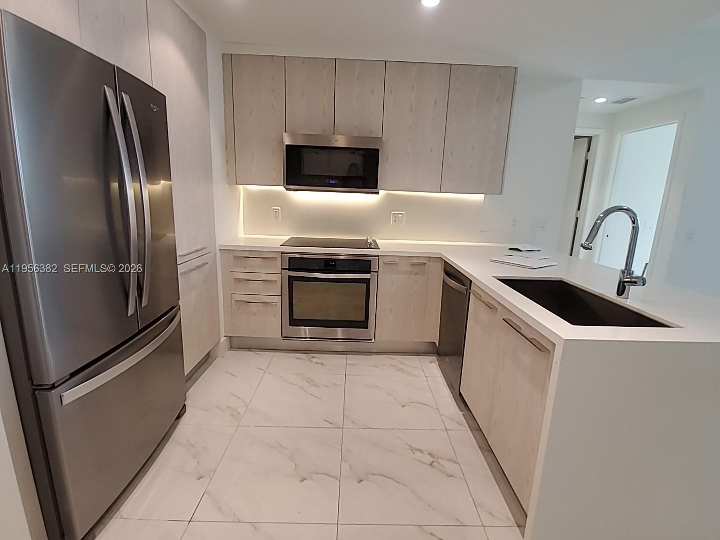 2000 Metropica Way, Unit 412 Sunrise, FL 33323 - Photo 3 of 18 a kitchen with stainless steel appliances granite countertop a refrigerator stove and sink