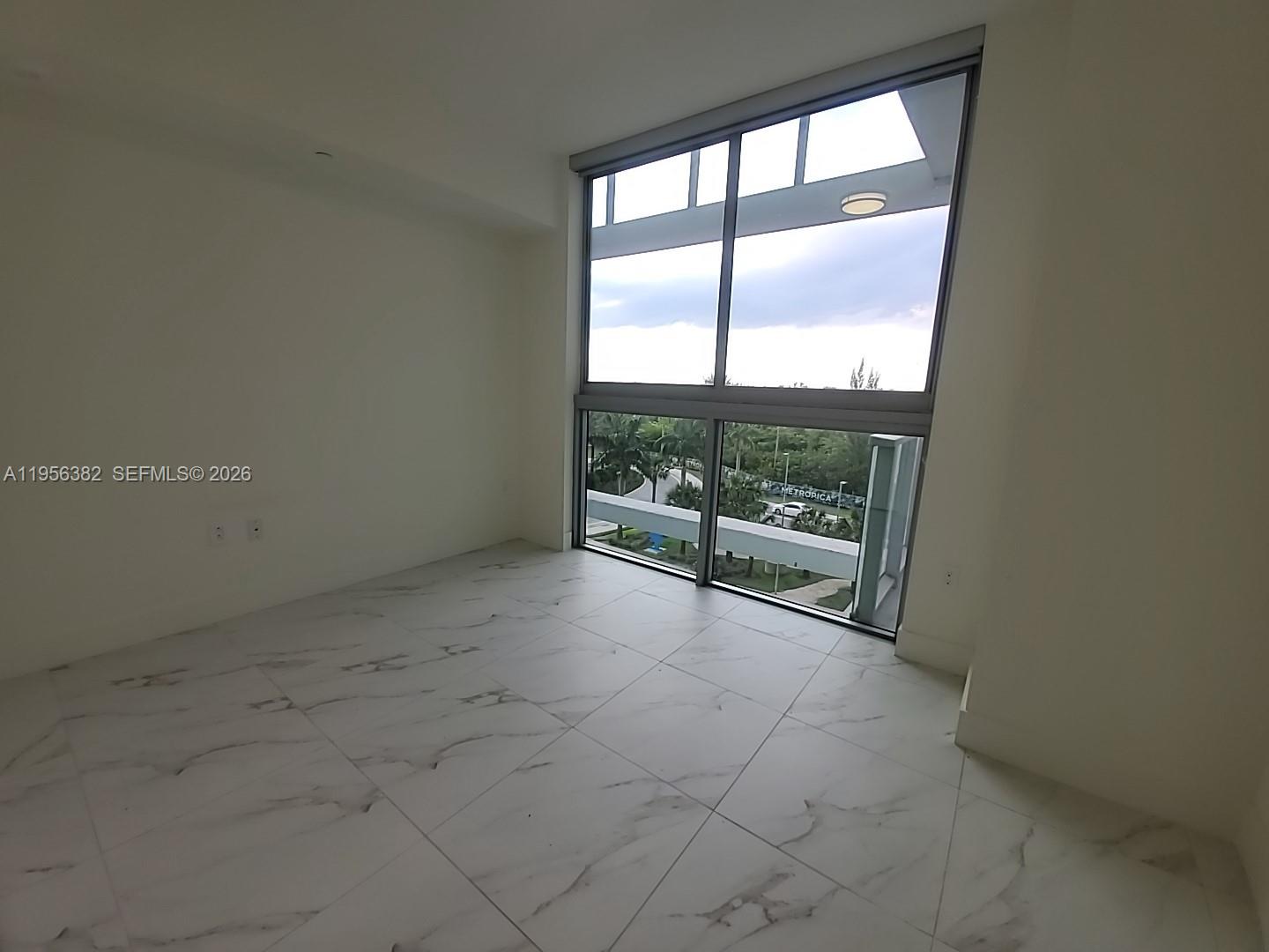 2000 Metropica Way, Unit 412 Sunrise, FL 33323 - Photo 5 of 18 an empty room with wooden floor and windows