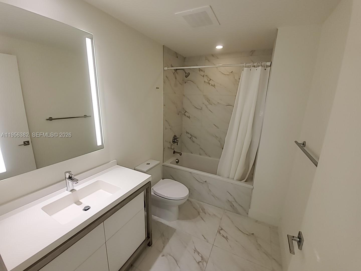 2000 Metropica Way, Unit 412 Sunrise, FL 33323 - Photo 8 of 18 a bathroom with a double vanity sink toilet mirror and shower