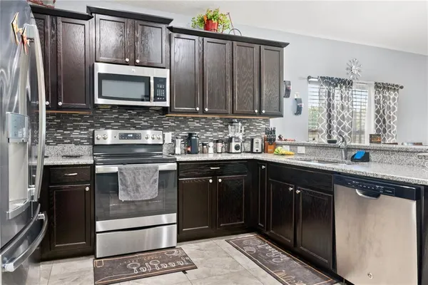 a kitchen with stainless steel appliances granite countertop a sink stove and cabinets