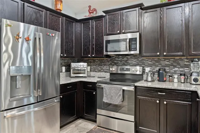 a kitchen with stainless steel appliances granite countertop a refrigerator stove and sink