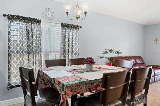 a dining room with furniture a chandelier and window