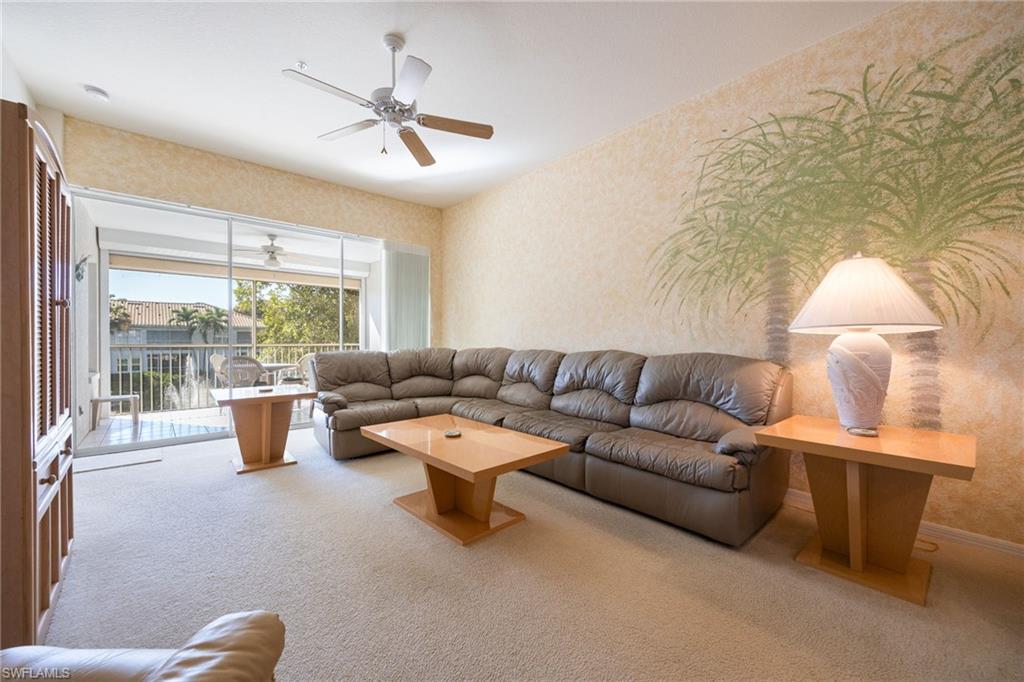 6927 Satinleaf Road North, Unit 203 Naples, FL 34109 - Photo 16 of 39 Carpeted living room with wallpapered walls and ceiling fan