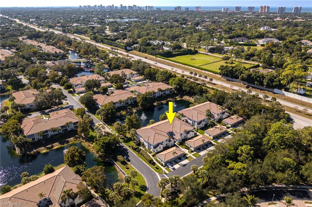 6927 Satinleaf Road North, Unit 203 Naples, FL 34109 - Photo 34 of 39 Aerial view of residential area featuring a large body of water and city skyline
