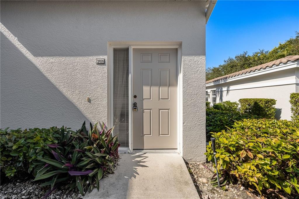 6927 Satinleaf Road North, Unit 203 Naples, FL 34109 - Photo 4 of 39 Doorway to property with stucco siding