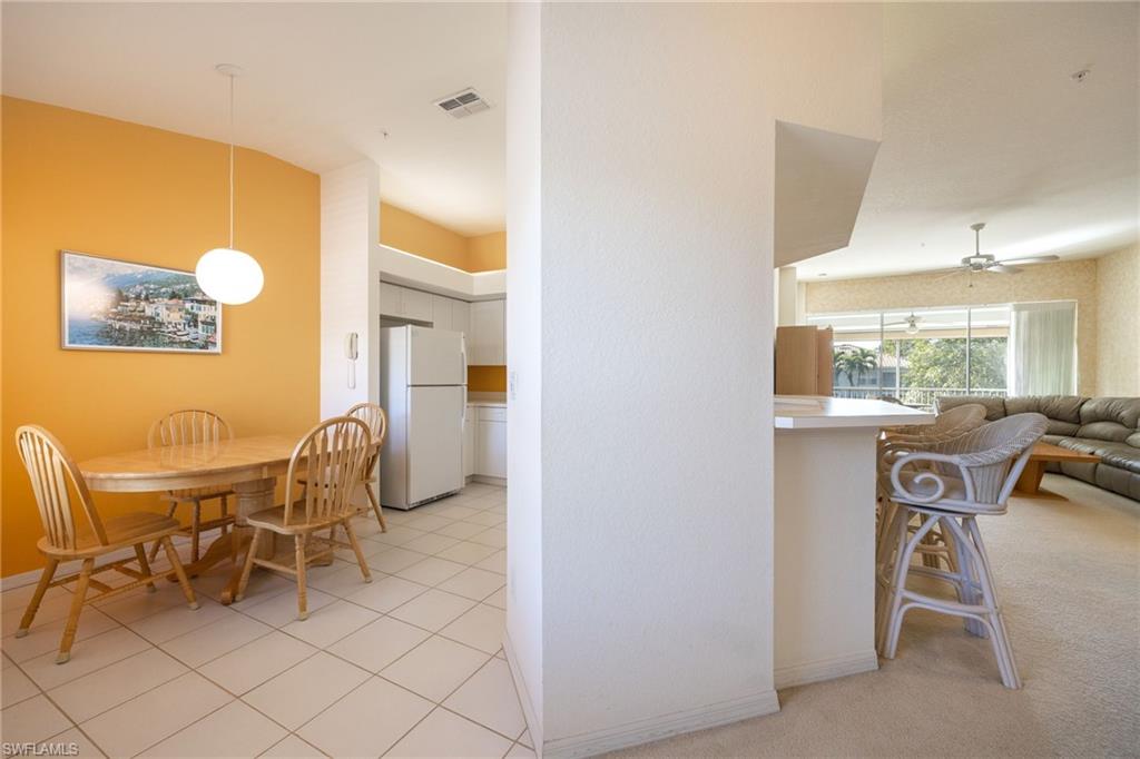 6927 Satinleaf Road North, Unit 203 Naples, FL 34109 - Photo 8 of 39 Dining area featuring a ceiling fan and light tile patterned floors