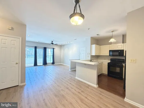 a large kitchen with kitchen island a sink dishwasher a stove a dining table and chairs with wooden floor