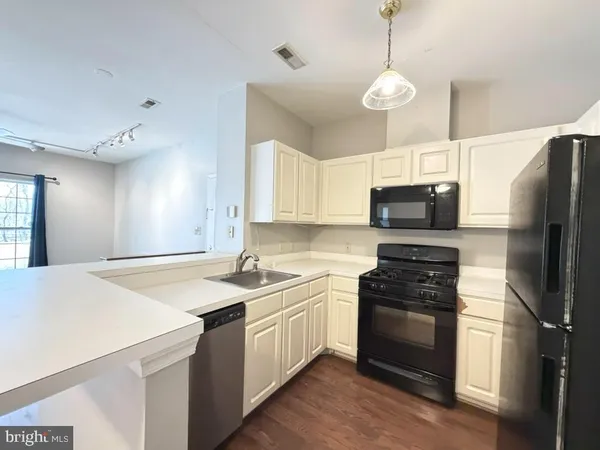 a kitchen with stainless steel appliances a stove a sink and a refrigerator