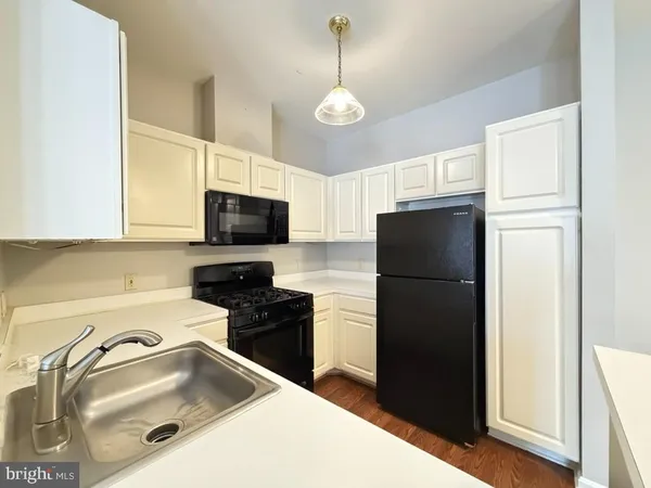 a kitchen with stainless steel appliances granite countertop a refrigerator a stove a sink and a microwave