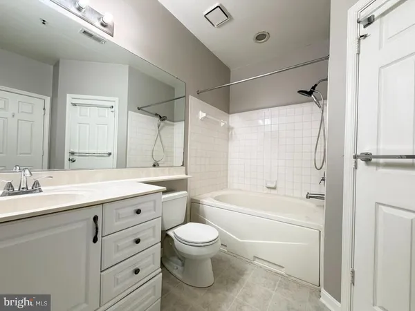 a bathroom with a granite countertop sink toilet tub and shower