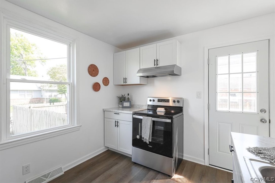 1006 Haskell Street Hopewell, VA 23860 - Photo 19 of 48 a kitchen with stainless steel appliances a stove a sink and white cabinets with wooden floor