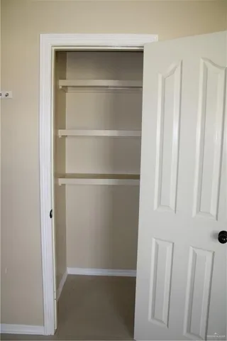 a view of walk in closet with empty racks