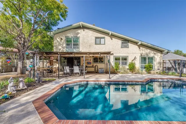 a view of a house with swimming pool and sitting area