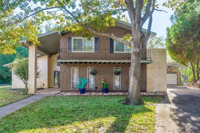 a view of a house with backyard and a tree