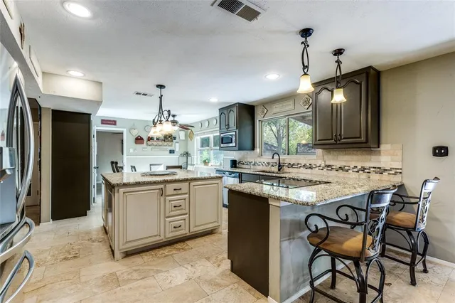 a kitchen with stainless steel appliances kitchen island granite countertop a sink and cabinets