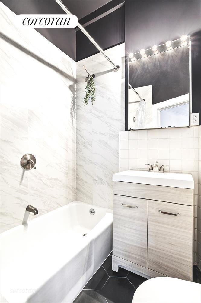 140 West 69th Street, Unit 103B Manhattan, NY 10023 - Photo 5 of 12 a bathroom with a sink and a bathtub