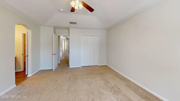 a view of empty room with ceiling fan