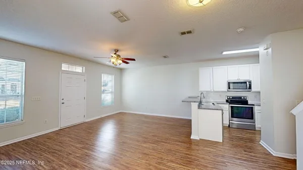 a view of a kitchen with stove and wooden floor