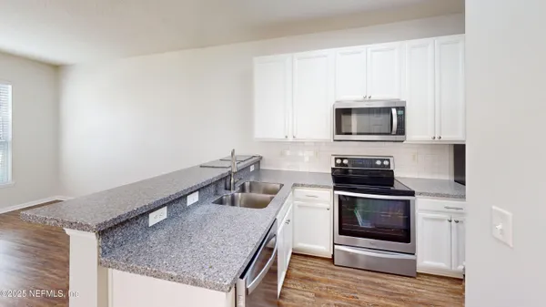 a kitchen with stainless steel appliances granite countertop a stove microwave and sink
