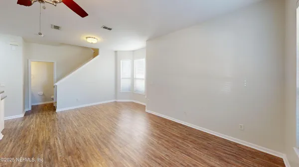 a view of an empty room with wooden floor