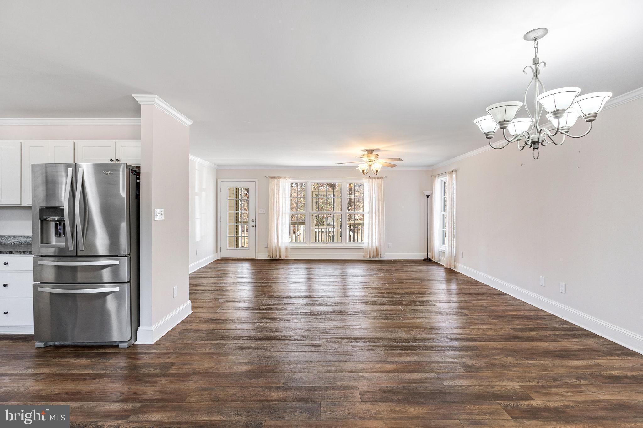16352 Bullocks Road Ruther Glen, VA 22546 - Photo 8 of 29 a view of an empty room with wooden floor and a kitchen