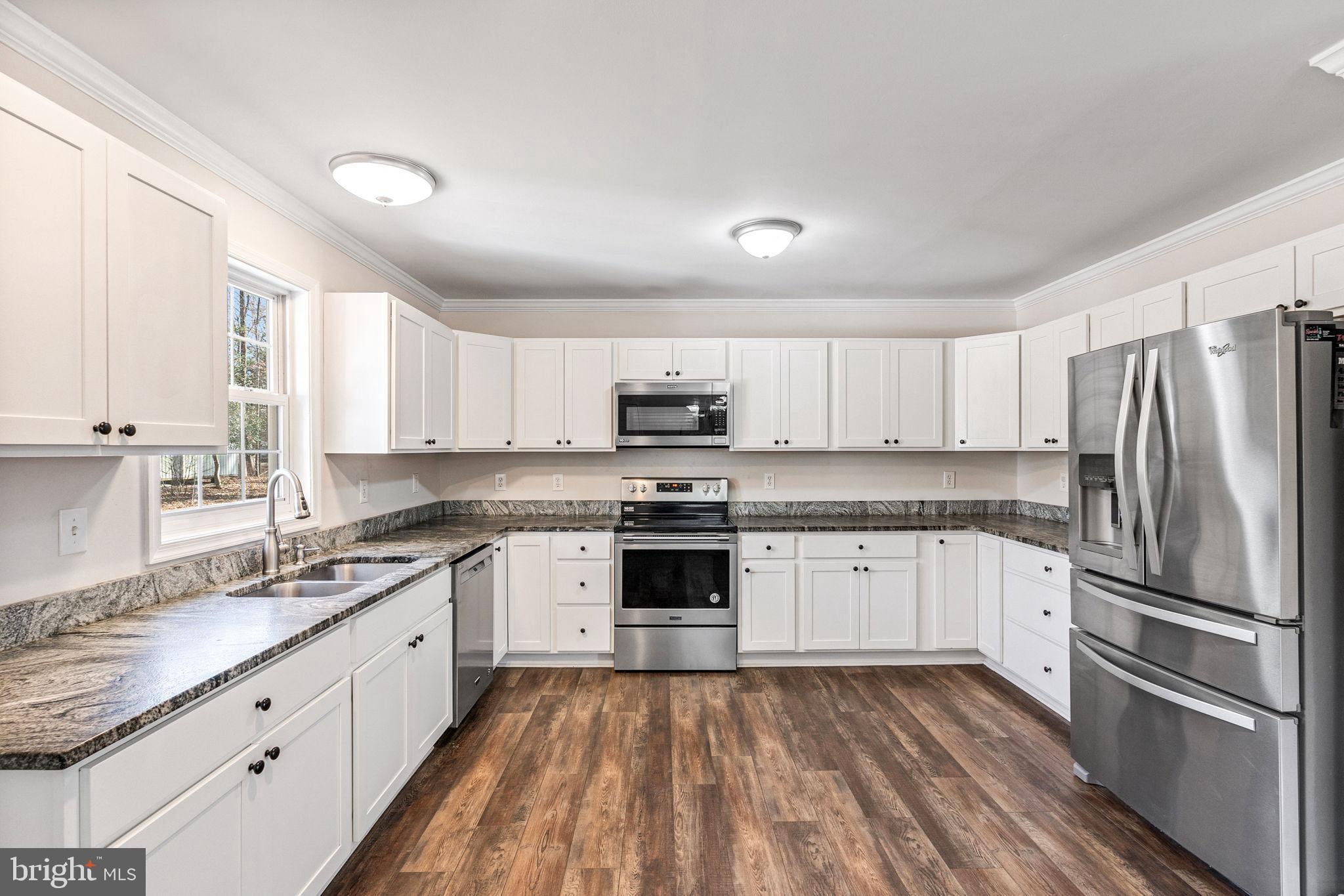 16352 Bullocks Road Ruther Glen, VA 22546 - Photo 10 of 29 a kitchen with granite countertop stainless steel appliances a sink cabinets and a window