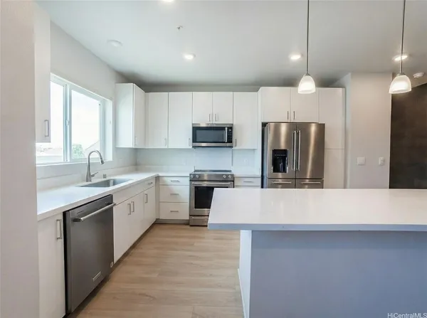a large kitchen with cabinets and stainless steel appliances